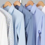 Close-up of different long sleeve shirt fabrics including oxford, twill, and poplin on a wooden hanger