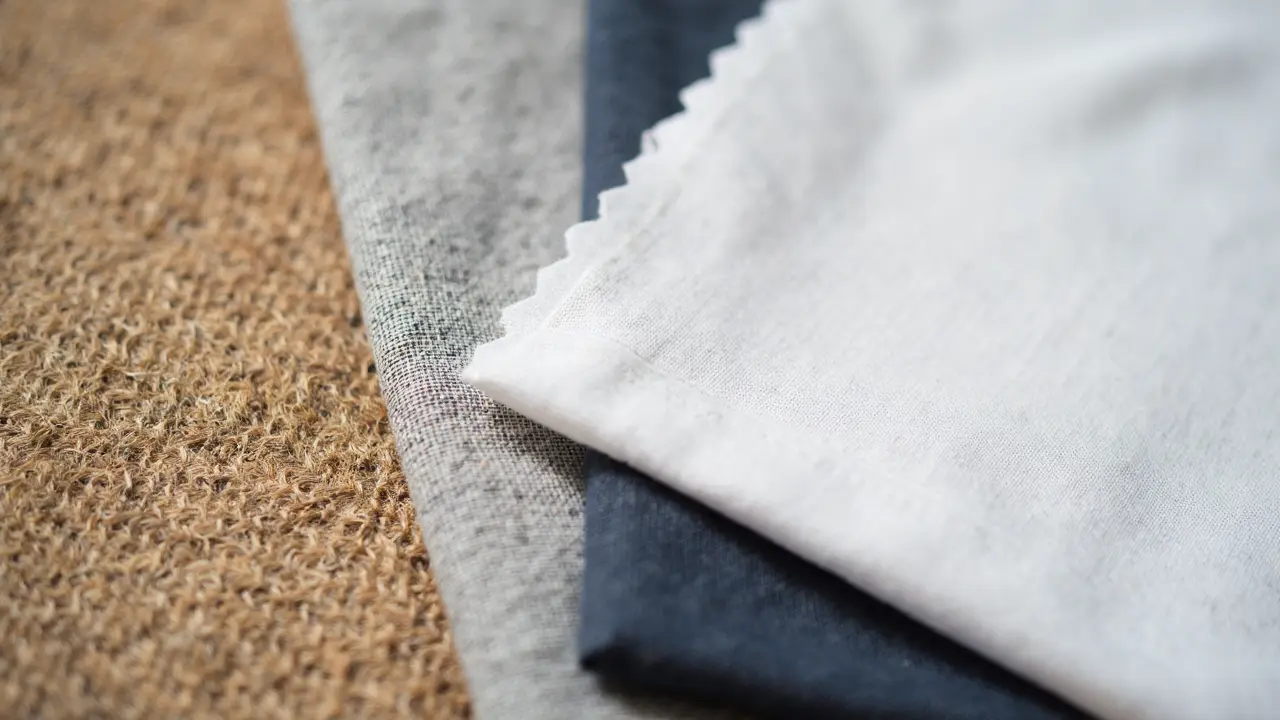 Close-up of sustainable t-shirt fabrics: organic cotton, linen blend, and recycled fiber textures